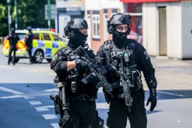 Armed police on Ilkeston Road, Nottingham, which is cordoned off after two people were found dead in the street.