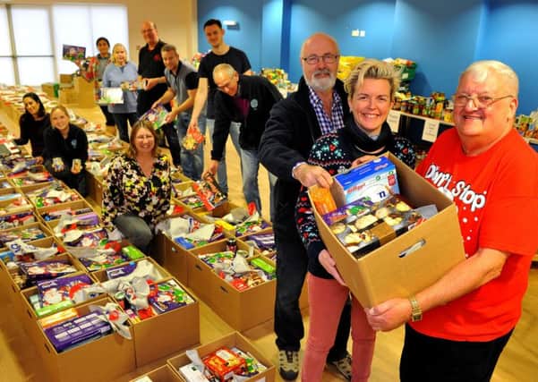 Lion Tony Parris (right) and members of the community packing the hampers in The Kings Church. Picture: Steve Robards