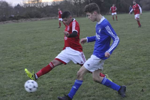 A Bexhill Town player tries to block a pass from a St Leonards Social opponent.