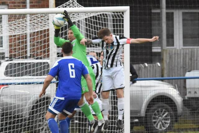 Simon Lehkyj catches the ball under pressure. Haywards Heath Town v Peacehaven. Picture by Grahame Lehkyj