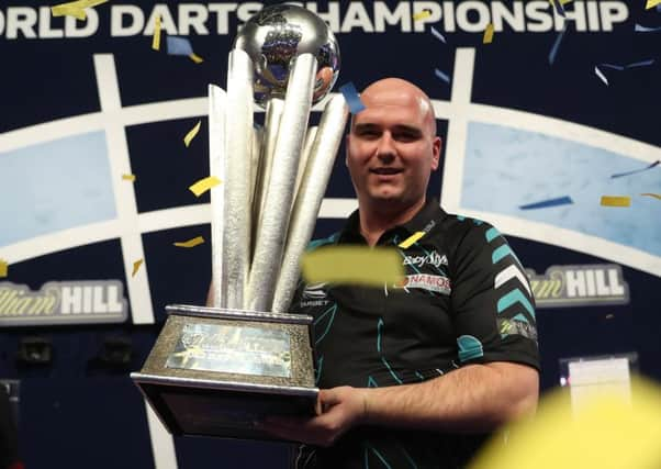 Rob Cross proudly clutches the William Hill World Darts Championship trophy. Picture courtesy Lawrence Lustig/PDC