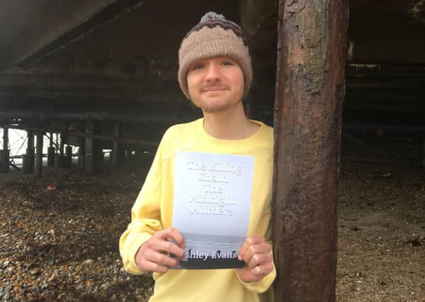 Ashley Evans, 17, from Goring with his murder novel The Killing Chain: The Midnight Murders under Worthing Pier, where one of the victims is found