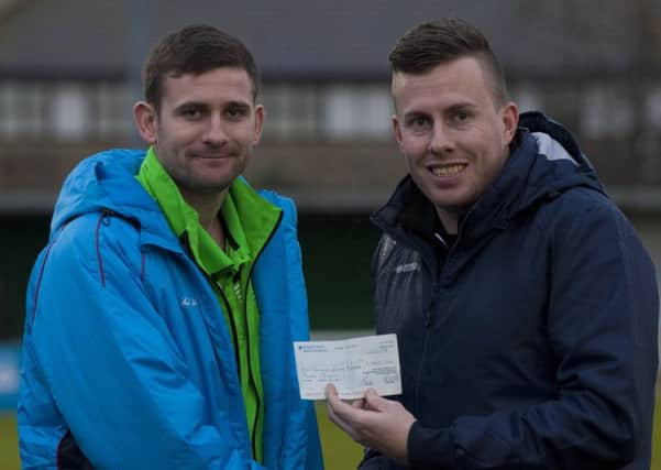 Ian Guppy hands James Crane the proceeds of the campaign to raise money for his surgery / Picture by Tommy McMillan
