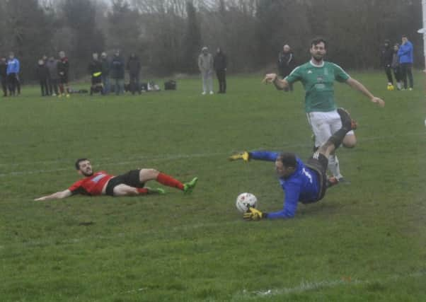 Bexhill Town goalkeeper Harry Killick denies Rye Town forward Charlie Stevens. Pictures by Simon Newstead