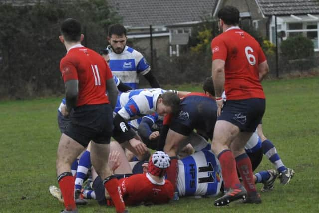 The two teams scrap for possession in chilly and wet conditions.