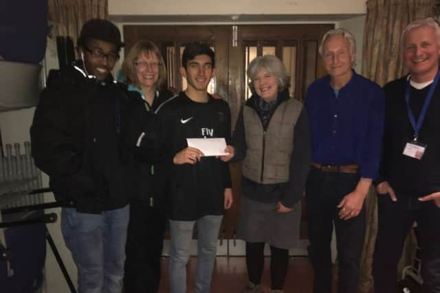 Sarah Nunn (centre) donating the cheque to players and coaches