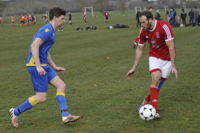 Bexhill Town midfielder Billy Trickett on the ball with Rye Town's Sam Richardson in close attendance.