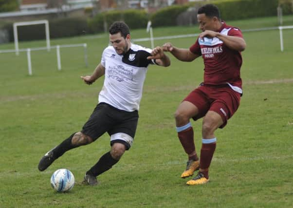 Bexhill United captain Craig McFarlane tries to clear under pressure from Wes Tate. Picture by Simon Newstead