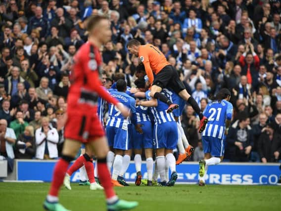 Goalkeeper Maty Ryan joins in the celebrations as Solly March's effort forces a Huddersfield own goal. Picture by PW Sporting Photography