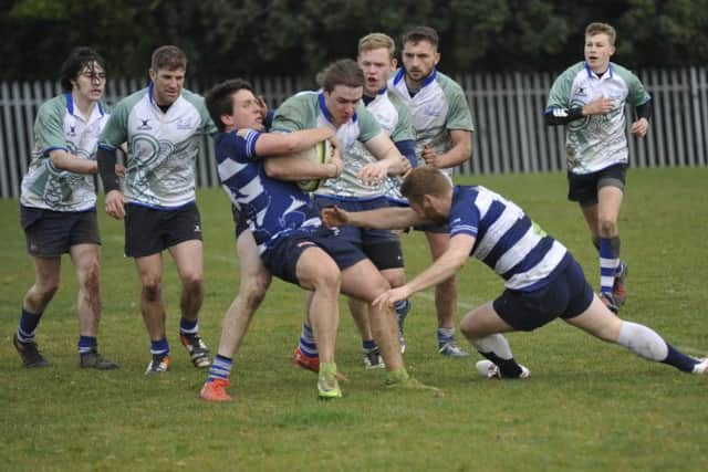 H&B winger Tim Sills is tackled by two Lewes opponents.