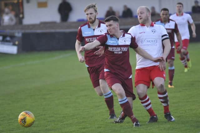 Liam Ward blocks the path of Langney Wanderers captain Paul Rogers.