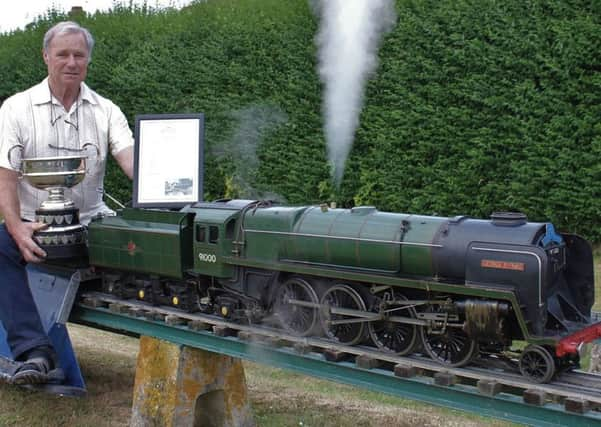 Lionel Flippance proudly displaying his steam locomotive trophy and award