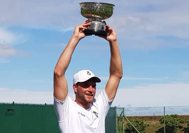 Lewis Burton lifts the men's singles trophy.