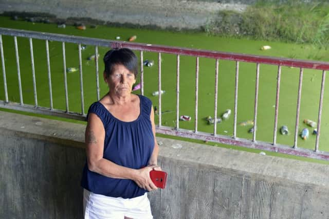 Susan Clarke next to some of the litter dumped in Shinewater Lake area in Eastbourne (Photo by Jon Rigby)