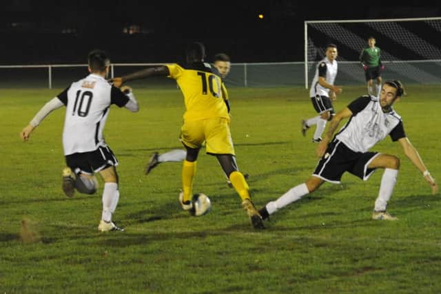 Haywards Heath midfielder Ansu Janneh runs between Bexhill United pair Nathan Lopez and Sammy Bunn