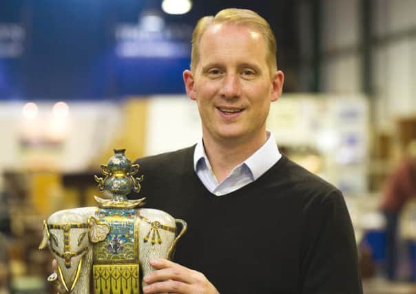 Tooveys Asian art specialist, Tom Rowsell, with one of a pair of rare Chinese Qianlong period cloisonne enamel elephants from an important London single owner collection of Asian art.