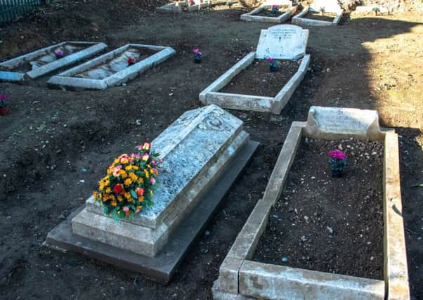 Flowers laid at the unearthed graves in the Brookside Avenue Industrial Estate graveyard in Rustington