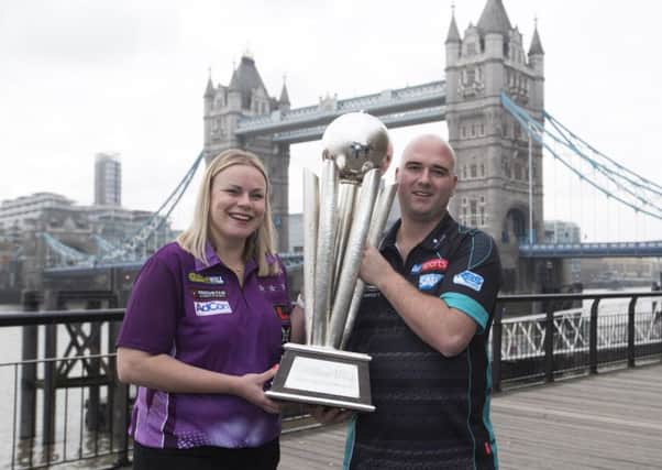 Rob Cross clutches the World Championship trophy alongside Anastasia Dobromyslova. Picture courtesy PDC/Lawrence Lustig