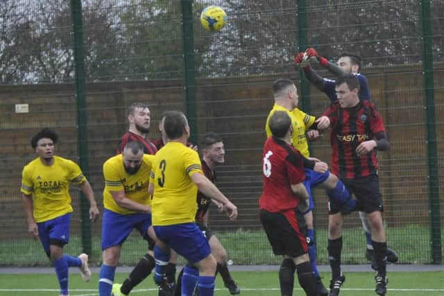 The South Coast Athletico goalkeeper punches the ball clear against Hawkhurst United II