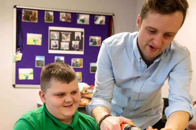 Teacher Andy Barbour helps an LVS Hassocks student to make an inventive musical instrument