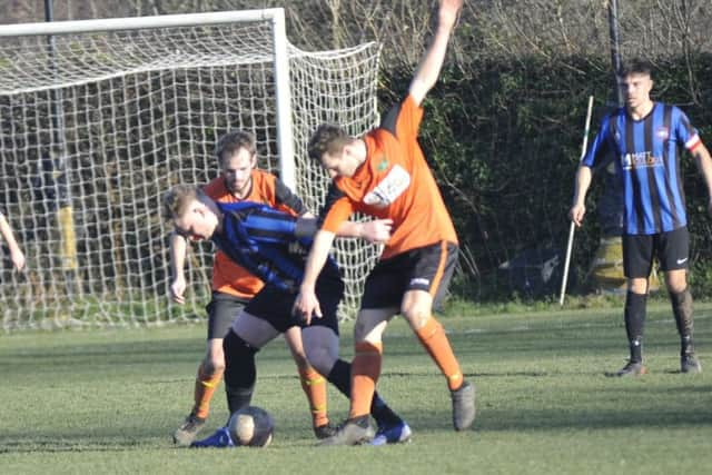 Two Westfield players attempt to dispossesses a Worthing Town opponent