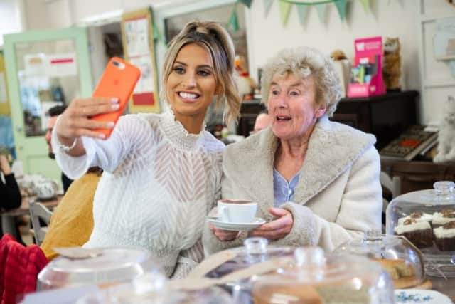 Ferne McCann takes a selfie with Shirley Margaret Hill, at a Royal Voluntary Service Centre in Lancing. Photo: Matt Crossick/PA Wire