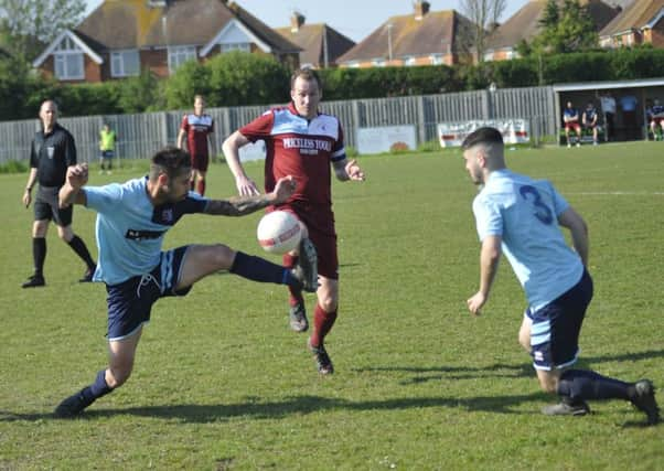 Lewis Hole, scorer of Little Common's winning goal, tussles for possession with AFC Uckfield Town captain Richie Welch. Picture by Simon Newstead