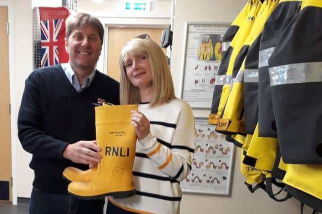 Steve Smith, Shoreham RNLI coxswain, hands the RNLI Mayday Welly to Karen Hilton, Mile Oak Football Club press officer