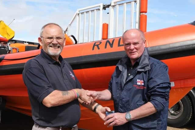 Tony Edwards hands over his pager to new LOM, Mark Hall. Photo by Kt Bruce. SUS-190705-134242001