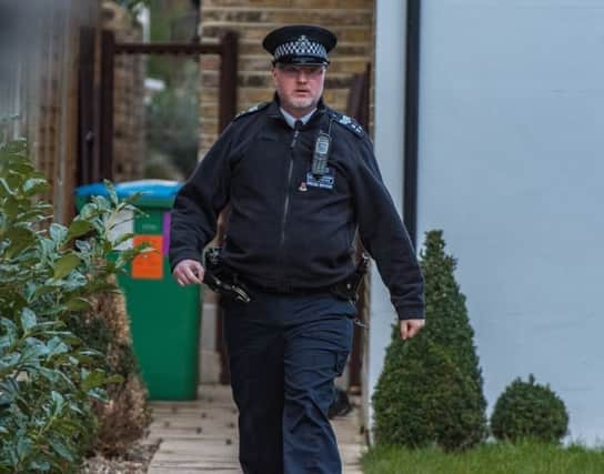 A police officer at the family's Twickenham home SUS-190905-110622001