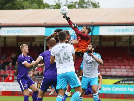 Crawley Town's Glenn Morris punches the ball away against Portsmouth on Saturday. Picture by Joe Pepler