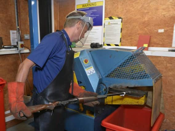 A gun being destroyed by 'the cruncher' - a machine at Hammond's Drive police station