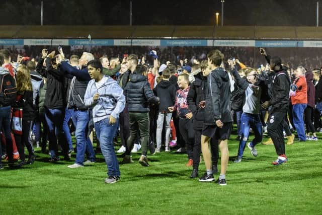 Crawley Town fans on the pitch after the Stoke City win