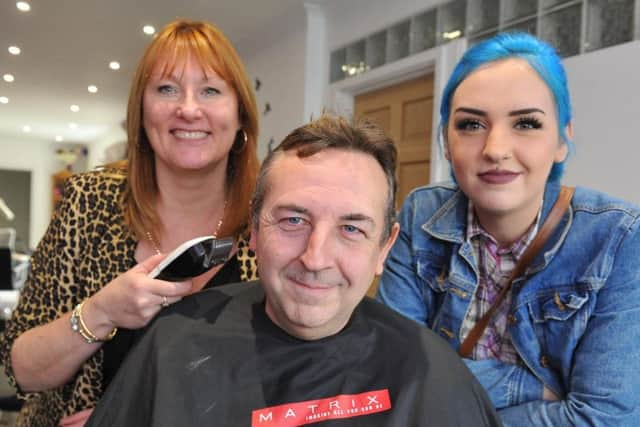 Richard Johnson with his daughter Lily Johnson (right) before having his head shaved by Linda Clarke (left). Photo: Steve Robards SR23101903