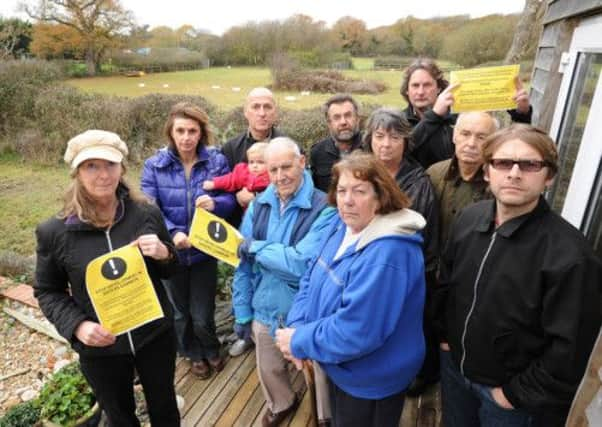 Protestors from Dunlop Close, Sayers Common in a back garden of one of the residents, with a view across the fields that will be built on, in the background.