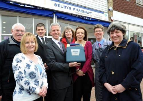 Ian and Sue Masters with the defibrillator that was bought for the village by Masters & Sons and is now situated outside Selby's Pharmacy