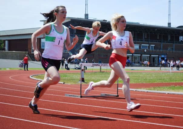 Clare Fraser and Harry Lyne, in the white and green, tackle the hurdles for Chichester Runners  Picture by Guy Ellis