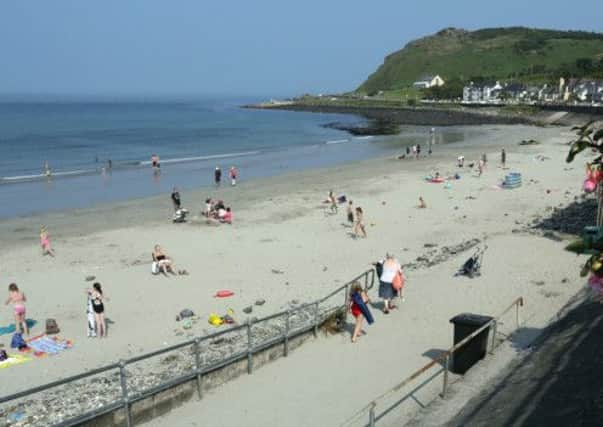 People enjoy the hot weather at Ballygally beach in Co Antrim, as weather forecasts predict upcoming thunder storms. PRESS ASSOCIATION Photo. Picture date: Monday July 22, 2013. See PA story WEATHER Heatwave. Photo credit should read: Paul Faith/PA Wire