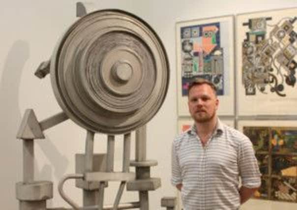 Simon Martin, Head of Collections and Exhibitions at Pallant House Gallery, with Eduardo Paolozzis Artificial Sun, circa 1964, sculpture in aluminium, and the screenprint of the same title and date.