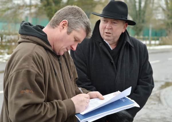 MEP Keith Taylor (right) getting parents to sign a petition to lower the speed limit to 20mph, outside Haddenham Jnr School