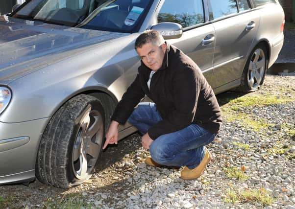 JPCT 041113 Tyres damaged. David Watts showing the damaged tyres on his car. Photo by Derek Martin