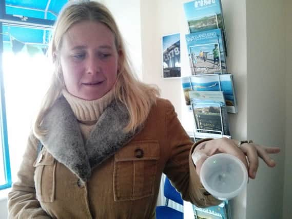 Sally Willis nervously holds the trapped false widow spider