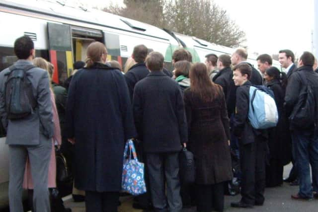 Commuters queueing to get onto a train