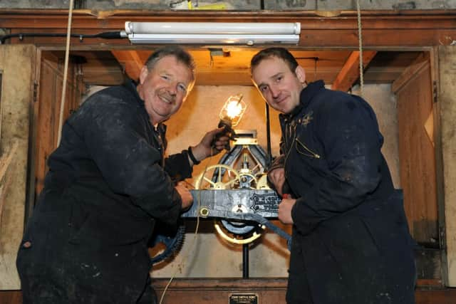 S08032H14 Engineers Dave Clarke, left, and Luke Ridge at work on the clock mechanism