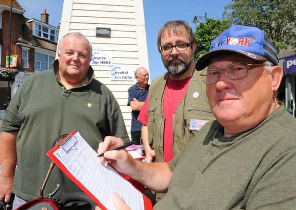 Councillor Mike Northeast, Alan Butcher and Mike Clough, chairman Arun Access Group, signing the petition.