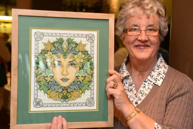 Joan Butland with her cross stitch exhibit. Photo by Derek Martin D14431149a