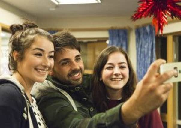 Ben takes a selfie with two siblings of a child supported by Shooting Star Chase SUS-140912-114608001