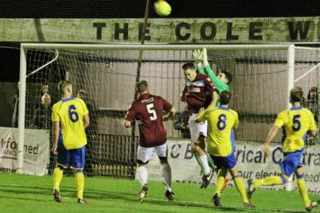 Hastings United defender Charlie Farmer challenges Burgess Hill Town goalkeeper Matt Morrish to a high ball during the Parafix Sussex Senior Challenge Cup third round tie at The Pilot Field on Monday night. Picture courtesy Joe Knight