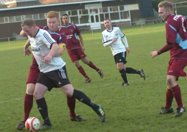 Bexhill United striker Andy Atkin and Little Common defender Zack McEniry tussle for possession. Picture by Simon Newstead (SUS-141229-092841002)