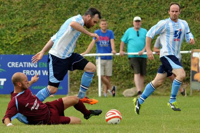 Little Common player-manager Russell Eldridge slides in to a tackle during the reverse fixture against Worthing United on the opening day of the season. Picture by Stephen Goodger (SUS-140814-120636002)